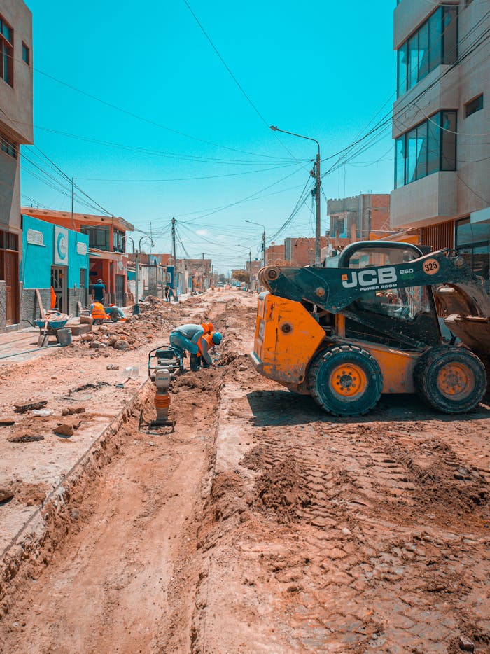 The Art of Drawing Readers In: Your attractive post title goes here Busy urban road construction scene with workers and construction machinery under a bright blue sky.